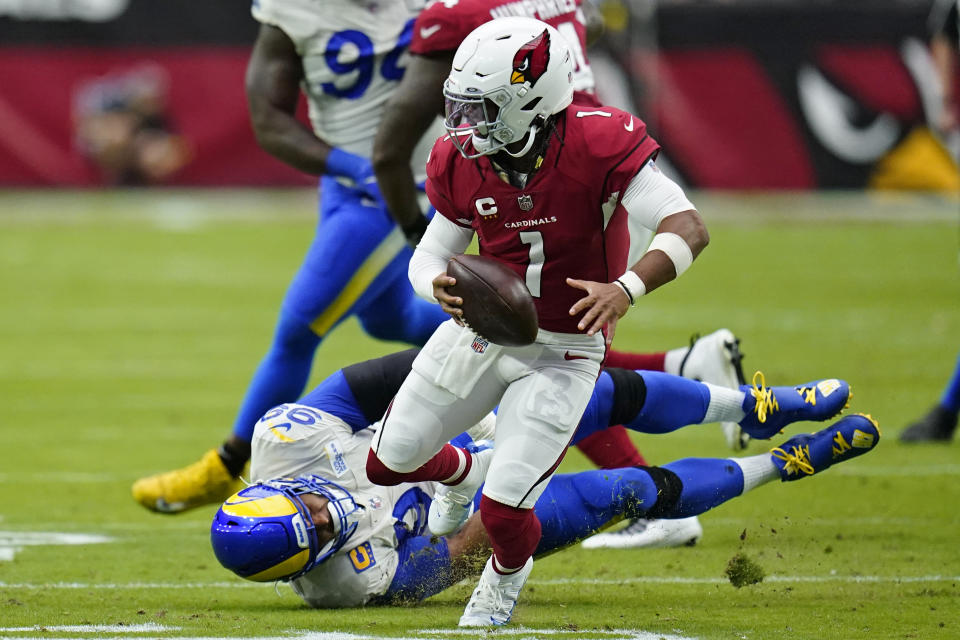 Arizona Cardinals quarterback Kyler Murray (1) avoids a tackle by Los Angeles Rams defensive tackle Aaron Donald (99) during the first half of an NFL football game, Sunday, Sept. 25, 2022, in Glendale, Ariz. (AP Photo/Ross D. Franklin)