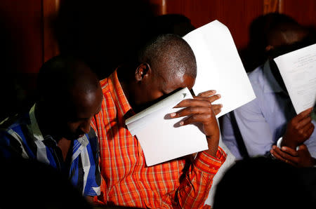 Suspects (L-R) Osman Ibrahim, Oliver Muthee, Guled Abdihakim and Joel Nganga cover their faces inside the Mililani Law Courts where they appeared in connection with the attack at the DusitD2 complex, in Nairobi, Kenya January 18, 2019. REUTERS/Thomas Mukoya