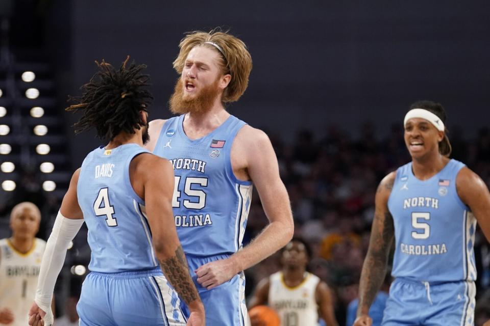 North Carolina guard RJ Davis, forward Brady Manek and forward Armando Bacot celebrate.