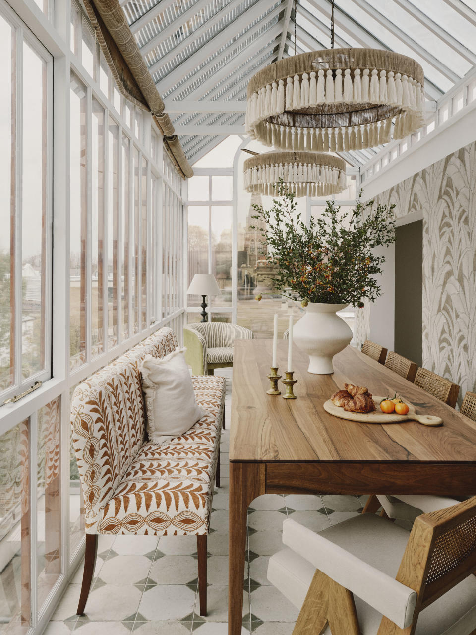 Modern sunroom with dining table and orange patterned bench