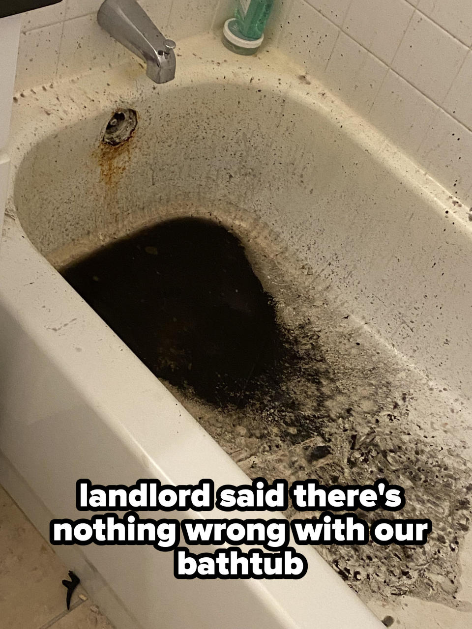 dark substance coming up from the drain in a bathtub