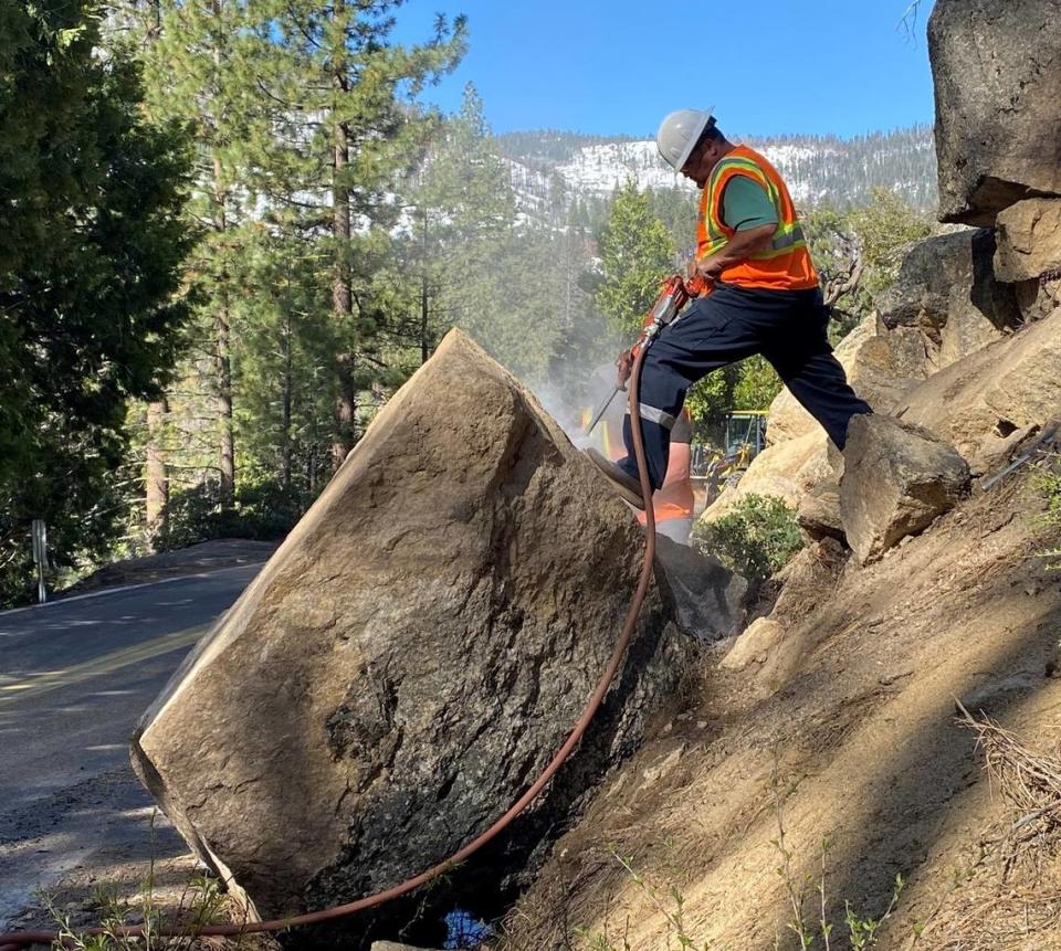 Equipment operator Dewayne Tillery breaks up a boulder amid the snow that blocked upper Highway 108. The California Department of Transportation had plowed it as far east as Kennedy Meadows as of May 15, 2023. Caltrans