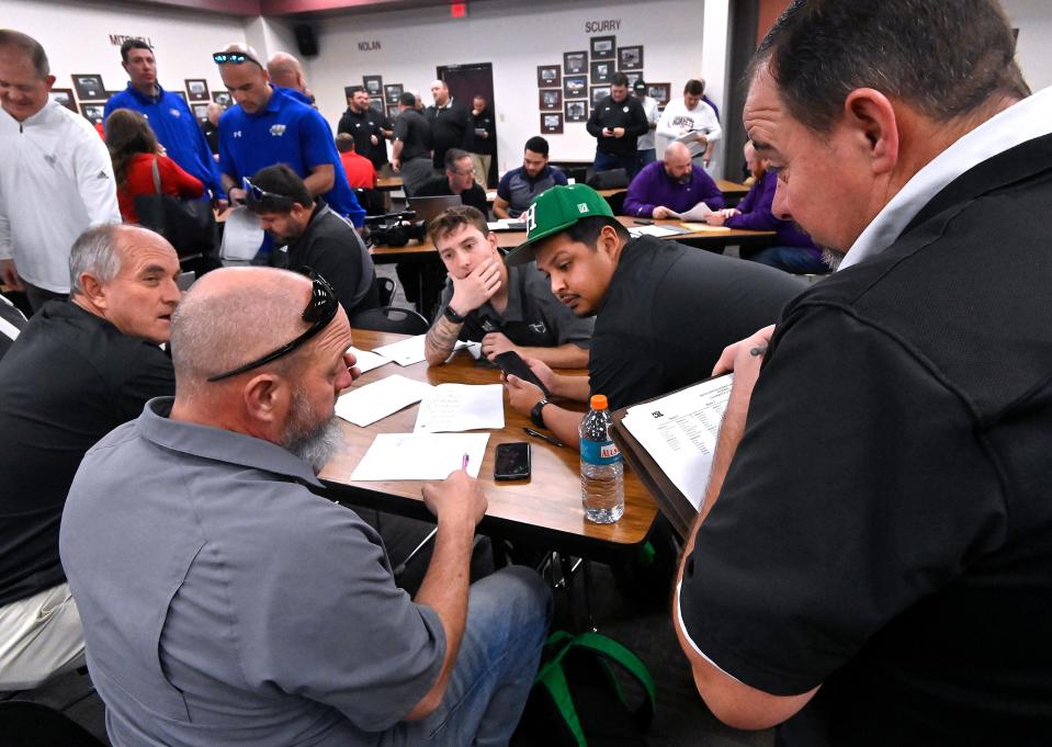 Coaches and administrative staff trade ideas and propositions as they iron-out high school football, basketball and volleyball schedules for the next two years during the UIL Realignment in Abilene Thursday.