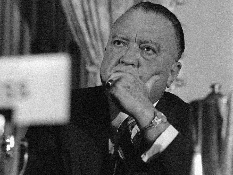 J. Edgar Hoover listens at the head table as he attends a luncheon of the Women’s National Press Club in Washington, DC.