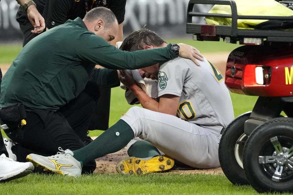 Oakland Athletics starting pitcher Chris Bassitt is attended to after getting hit in the head from a ball hit by Chicago White Sox's Brian Goodwin during the second inning of a baseball game, Tuesday, Aug. 17, 2021, in Chicago. (AP Photo/Charles Rex Arbogast)