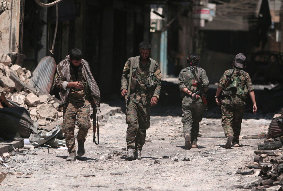 <p>Syria Democratic Forces (SDF) fighters walk on the rubble of damaged shops and buildings in the city of Manbij, in Aleppo Governorate, Syria, Aug. 10, 2016. (REUTERS/Rodi Said) </p>