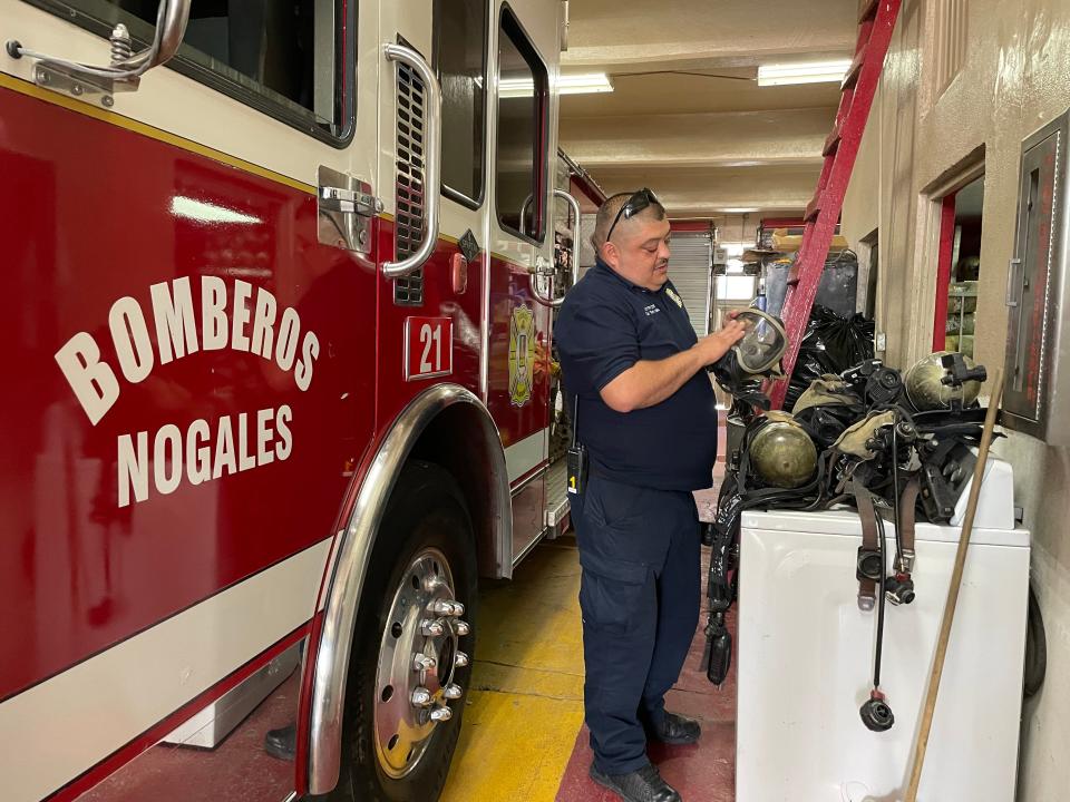Cesar Ramón Velez, with Nogales, Sonora firefighters, holds a firefighter mask. Crews use protective equipment every time they respond to emergencies but the budget of the voluntary fire stations is limited and often they rely on gear donations from the United States.