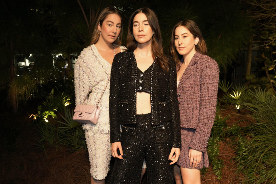 Este, left, Danielle, center, and Alana Haim, right, arrive for an event celebrating 100 years of the fragrance Chanel No. 5 during Miami Art Week, Friday, Dec. 3, 2021, in the Design District neighborhood of Miami. Artist Es Devlin was commissioned by Chanel to create an installation titled "Five Echoes" for the celebration. Miami Art Week is an annual event centered around the Art Basel Miami Beach fair. (AP Photo/Lynne Sladky)