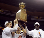 From left, Wichita State's Ron Baker, Fred VanVleet and Cleanthony Early celebrate with the trophy after their victory over Indiana State in an NCAA college basketball game in the championship of the Missouri Valley Conference men's tournament, Sunday, March 9, 2014, in St. Louis. (AP Photo/Bill Boyce)