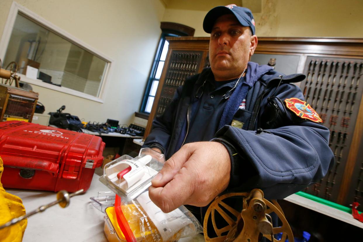 Travis Rebello, hazardous materials coordinator, holds a Narcan device at Station 2 in downtown New Bedford.
