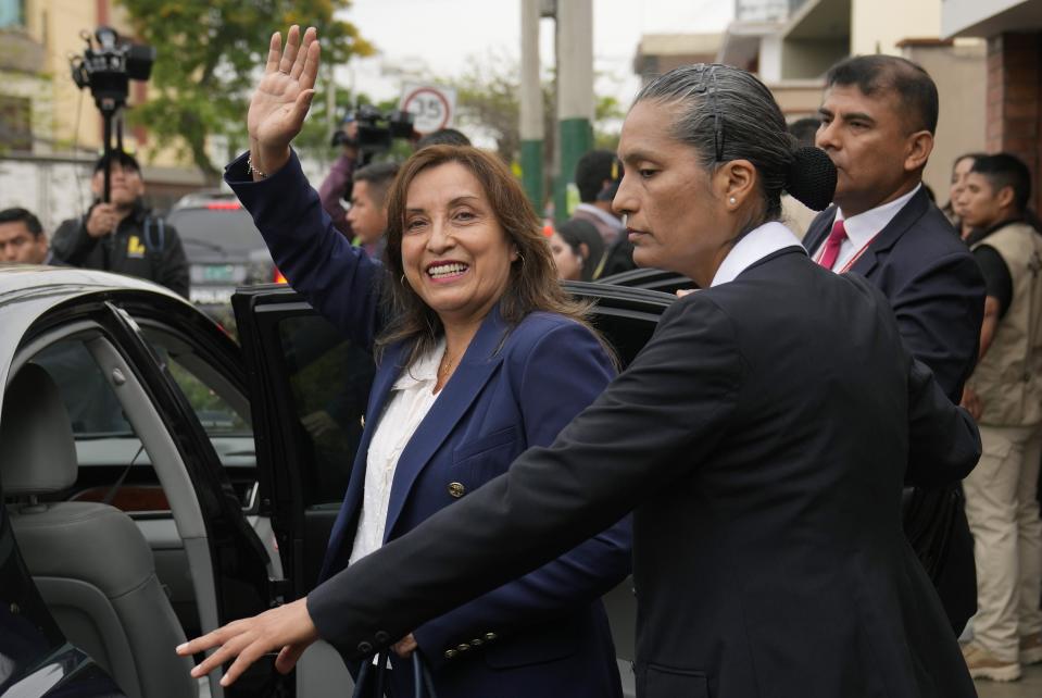 Peru's new President Dina Boluarte waves to the press as she leaves her home in Lima, Peru, Thursday, Dec. 8, 2022. Peru's Congress voted to remove President Pedro Castillo from office Wednesday and replace him with the vice president, shortly after Castillo tried to dissolve the legislature ahead of a scheduled vote to remove him. (AP Photo/Martin Mejia)