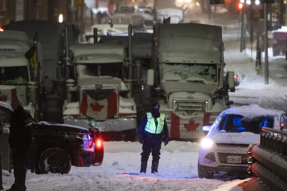 An OPP officer mans a roadblock along Wellington Street, as a winter storm warning is in effect, during a protest against COVID-19 measures in Ottawa, on Friday, Feb. 18, 2022. (Justin Tang /The Canadian Press via AP)