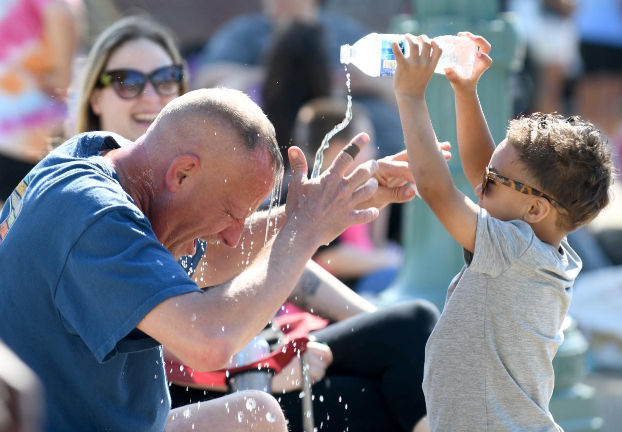 Marty Slabaugh of Canton faces a sneak attack with a water bottle by grandson, Kaydan Summers, 3, of Canton before the start of Canton Memorial Day Parade and Ceremony.