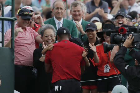 Golf - Masters - Augusta National Golf Club - Augusta, Georgia, U.S. - April 14, 2019 - Tiger Woods of the U.S. Tiger Woods embraces his son Charlie Axel as his mother Kultida Woods (L), daughter Sam Alexis and girlfriend Erica Herman (R) look on after he won the 2019 Masters. REUTERS/Mike Segar