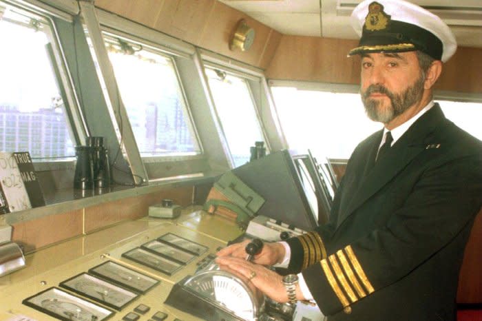 Capt. John Burton Hall, head master of the luxury cruise liner Queen Elizabeth 2, stands at the helm on the bridge. UPI File Photo