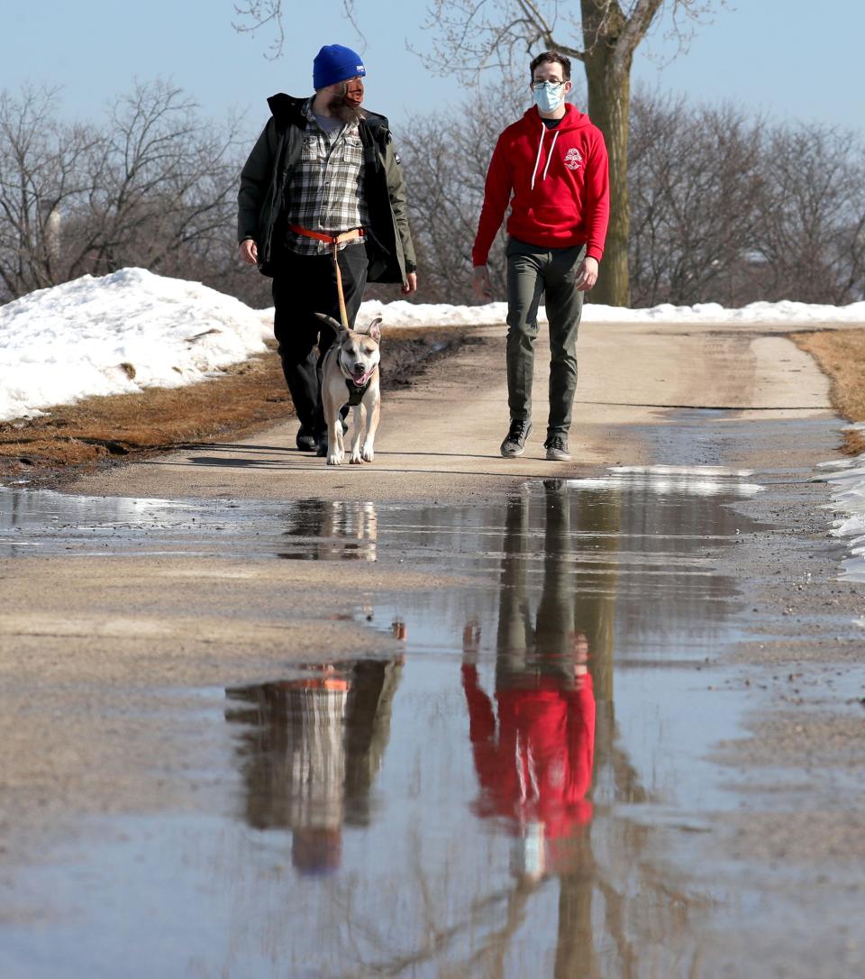 Ian Gunther, left, and Matt Balz, both of Milwaukee, walk with Gunther's 4-year-old dog, Ami, a pit bull-husky mix, at Kilbourn Reservoir Park on East North Avenue in Milwaukee on Saturday, Feb. 27, 2021.