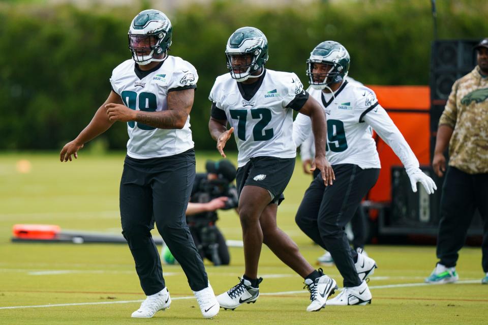 Philadelphia Eagles' Jalen Carter, left, and Moro Ojomo, center, warm up during the NFL's rookie football minicamp, Friday, May 5, 2023, in Philadelphia.