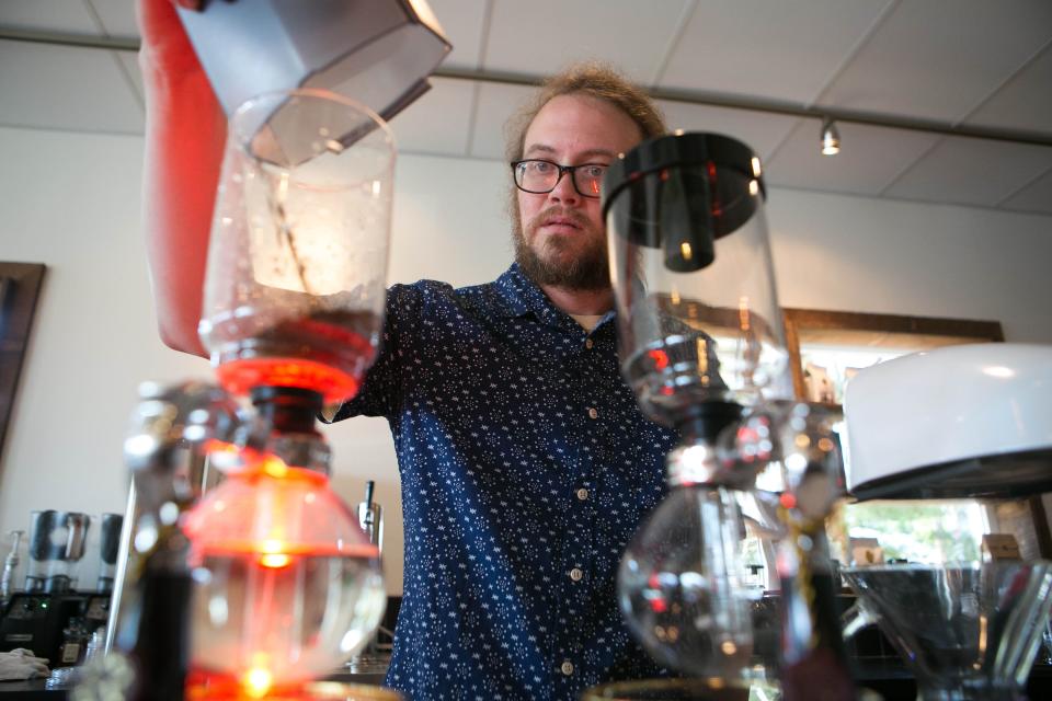 Todd Purse uses a vacuum brewer as he serves customers at Brew HaHa! in 2016.