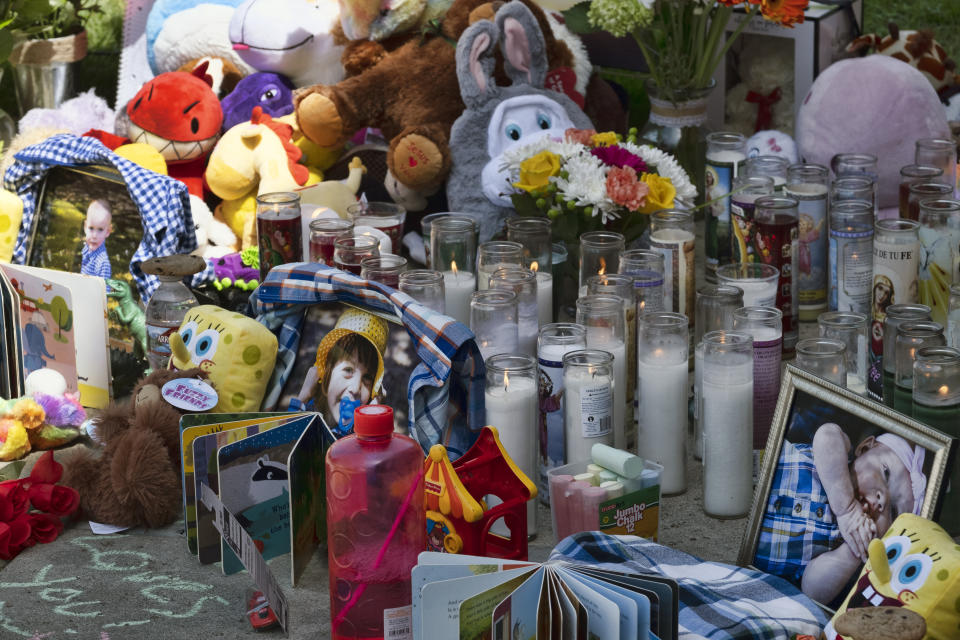 Photos, candles, flowers and balloons are placed as a memorial for three children who were killed at the Royal Villa apartments complex in the Reseda section of Los Angeles, on Monday, April 12, 2021. Authorities have identified 3-year-old Joanna Denton Carrillo, her 2-year-old brother, Terry, and 6-month-old sister, Sierra, as the three young children who were killed over the weekend. Their mother is the suspect in their deaths and was being held in a central California jail. (AP Photo/Richard Vogel)