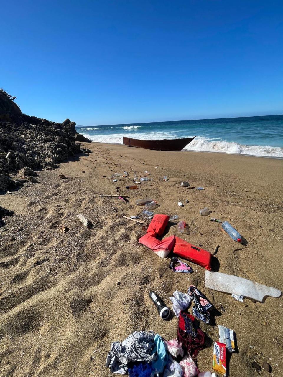 The boat on the beach on Rincón, Puerto Rico, on Jan. 24, 2022, along with items reportedly left behind by Haitian migrants.