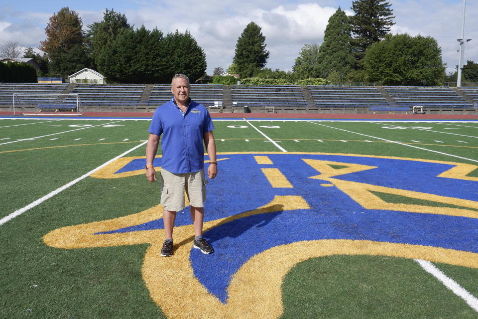 Joe Kennedy, assistant coach for the Bremerton High School Knights football team, stands near the 50-yard line in Bremerton, Wash., on Wednesday, Aug. 30, 2023. Years after Kennedy left the team over objections to his post-game praying on the field, he has returned to the gridiron thanks to a Supreme Court decision, and his first game back is Friday, Sept. 1, 2023. (AP Photo/Ed Komenda)