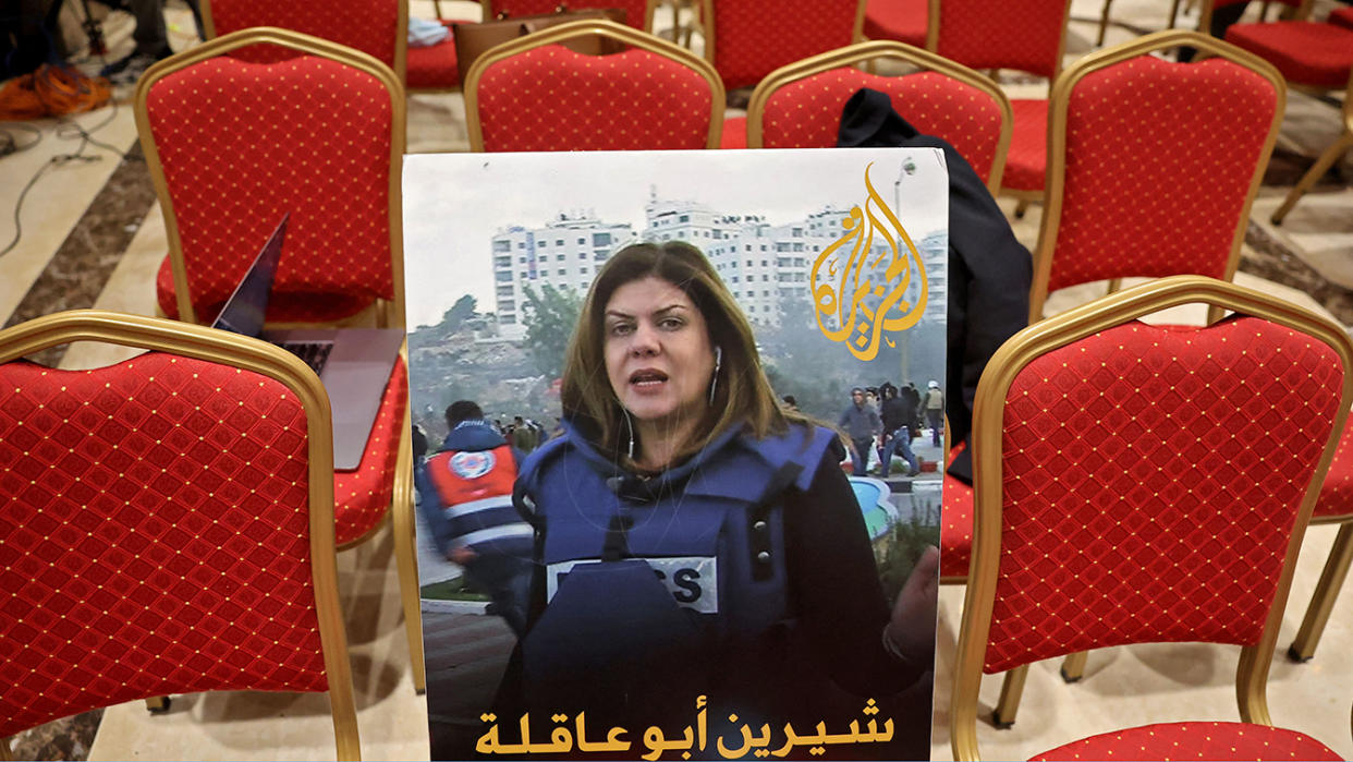 A photo of Shireen Abu Akleh, with a caption in Arabic reading “Shireen Abu Akleh, the voice of Palestine,” is placed among chairs for reporters ahead of a news conference.