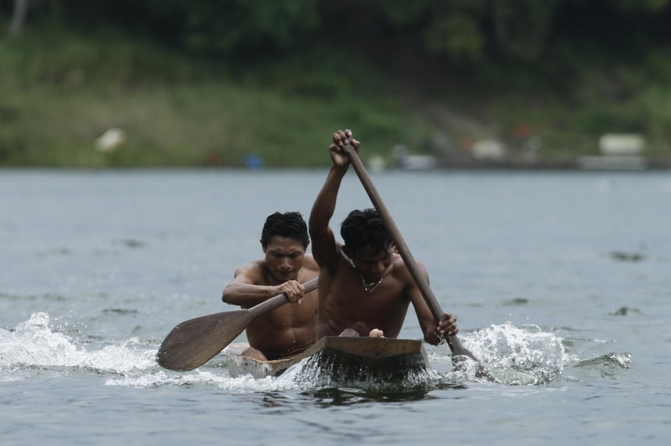 In this Nov. 25, 2018 photo, two Guna indigenous men row in the dugout canoe competition during the second edition of the Panamanian indigenous games on Lake Bayano, Panama. Lake Bayano is one of the main reservoirs in Panama. (AP Photo/Arnulfo Franco)