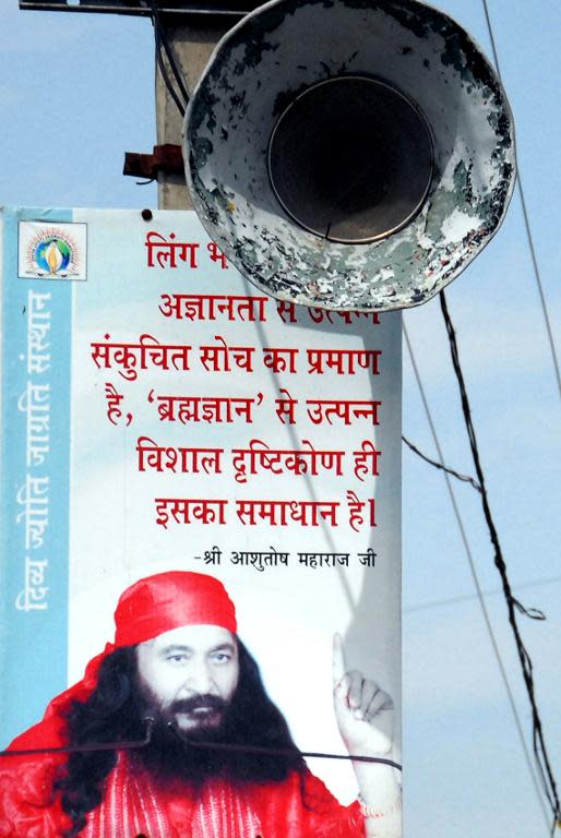 A board featuring an image of Indian spiritual leader Ashutosh Maharaj stands outside the Divya Jyoti Jagrati Sansthan in Nurmahal on the outskirts of Jalandhar on March 11, 2014