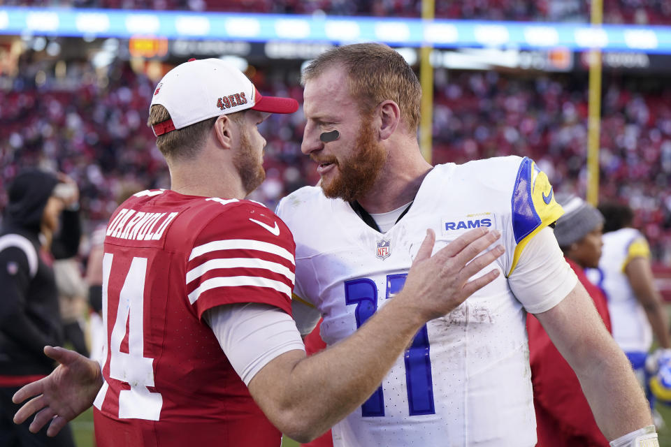 San Francisco 49ers quarterback Sam Darnold, left, greets Los Angeles Rams quarterback Carson Wentz after an NFL football game in Santa Clara, Calif., Sunday, Jan. 7, 2024. (AP Photo/Loren Elliott)