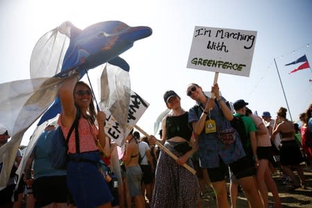 Protestors affiliated with Greenpeace take part in a procession during Glastonbury Festival at Worthy farm in Somerset