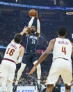 Orlando Magic's Terrence Ross (31) shoots between Cleveland Cavaliers' Cedi Osman (16) and Evan Mobley (4) in the first half of an NBA basketball game, Saturday, Nov. 27, 2021, in Cleveland. (AP Photo/Tony Dejak)