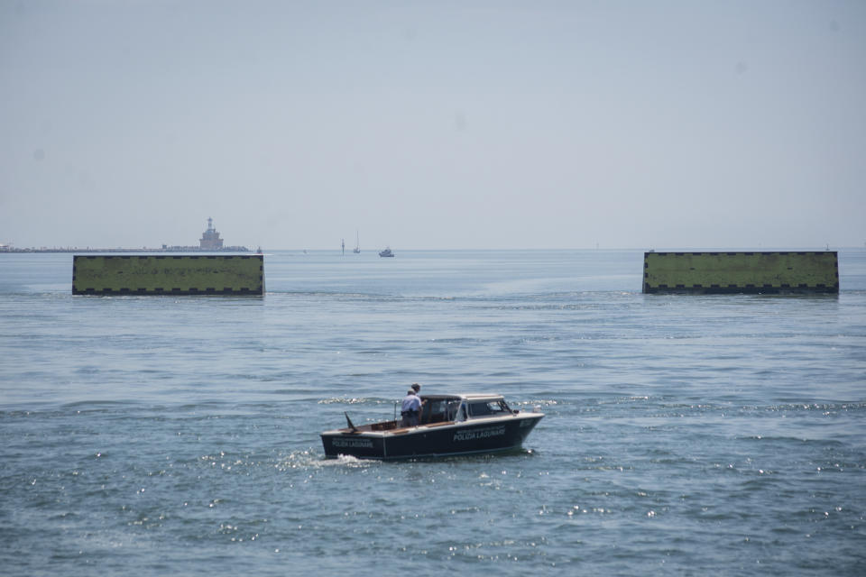 Moveable flood gates rise from the sea in the Venice lagoon, Italy, Friday, July 10, 2020. Venice has conducted a trial run an ambitious anti-flood system of 78 inflatable barriers in the hopes of protecting the lagoon city from devastating high tides. Premier Giuseppe Conte on Friday at a ceremony in Venice pressed a button that activated compressors to pump air into the bright yellow barriers, which then started rising from the sea to act a kind of a dike-on-demand. (Claudio Furlan/LaPresse via AP)