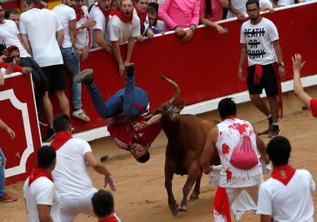 A reveller is tossed by a wild cow following the third running of the bulls at the San Fermin festival in Pamplona, Spain July 9, 2017. REUTERS/Joseba Etxaburu