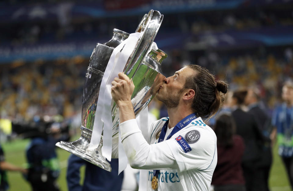 FILE - Real Madrid's Gareth Bale celebrates with the trophy after winning the Champions League Final soccer match between Real Madrid and Liverpool at the Olimpiyskiy Stadium in Kiev, Ukraine, Saturday, May 26, 2018. (AP Photo/Pavel Golovkin, File)