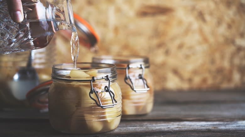 Pouring vinegar into pickling jars