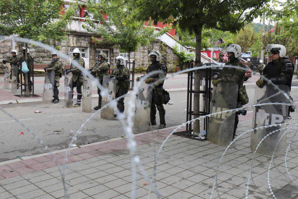KFOR soldiers stand near a barbed wire in front of the city hall in the town of Zvecan, northern Kosovo, Wednesday, May 31, 2023. Hundreds of ethnic Serbs began gathering in front of the city hall in their repeated efforts to take over the offices of one of the municipalities where ethnic Albanian mayors took up their posts last week. (AP Photo/Bojan Slavkovic)