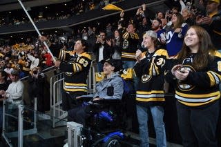 A.J. Quetta is surrounded by friends and family as the honorary banner captain before the Bruins hosted the New York Islanders to open the second round of the NHL playoffs last season.