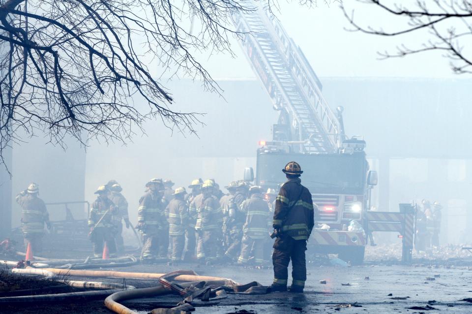 A firefighter looks on as others continue extinguishing the March 2020 blaze at the Conant Thread factory complex on the Central Falls/Pawtucket line.