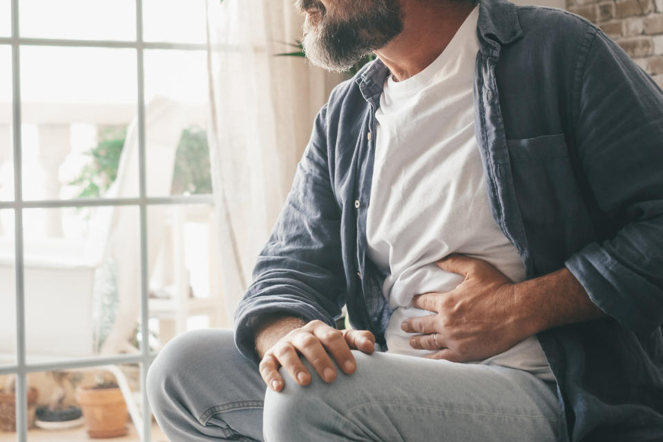 Man holding his stomach. (Getty Images)