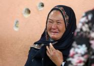 An Afghan woman cries while looking for her relative at a hospital which came under attack yesterday in Kabul