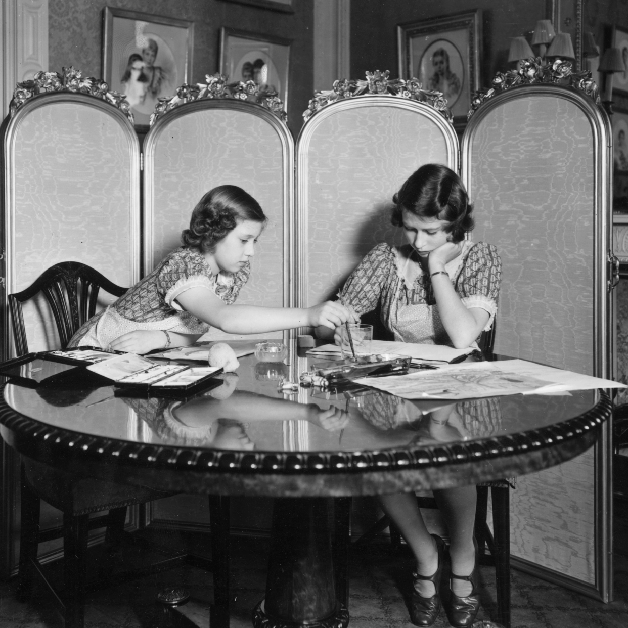  Princess Margaret Rose (1930 - 2002) and Princess Elizabeth (right) working on paintings in the school room of Buckingham Palace. 