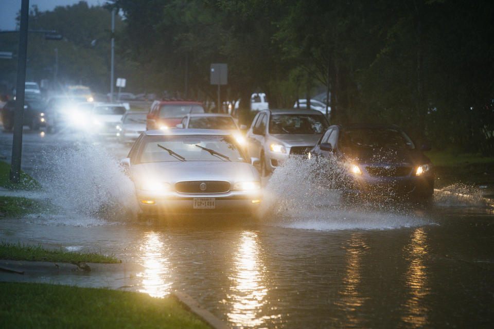 Vehicles splash through heavy water filling Chimney Rock, south of Brays Bayou in Houston, Tuesday, Sept. 17, 2019. Officials in the Houston area were preparing high-water vehicles and staging rescue boats Tuesday as Tropical Storm Imelda moved in from the Gulf of Mexico, threatening to dump up to 18 inches of rain in parts of Southeast Texas and southwestern Louisiana over the next few days. (Mark Mulligan/Houston Chronicle via AP)