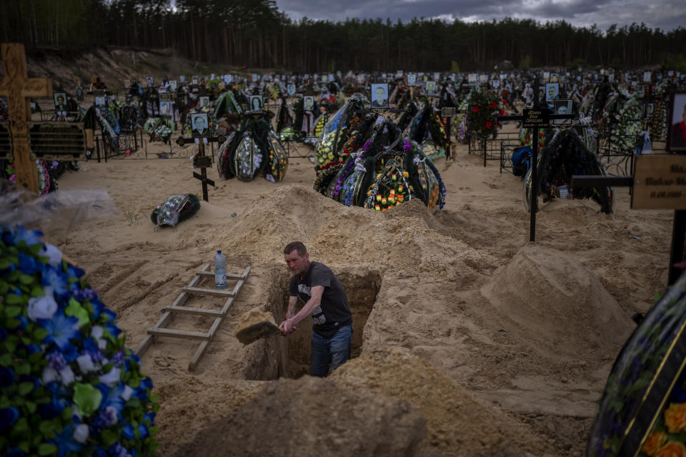 Gravedigger Alexander, digs a grave at the cemetery of Irpin, on the outskirts of Kyiv, on Wednesday, April 27, 2022. (AP Photo/Emilio Morenatti)