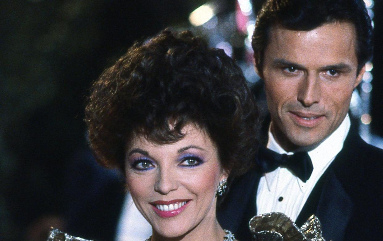 Michael Nader and Joan Collins on the set of Dynasty in 1985 - Alamy