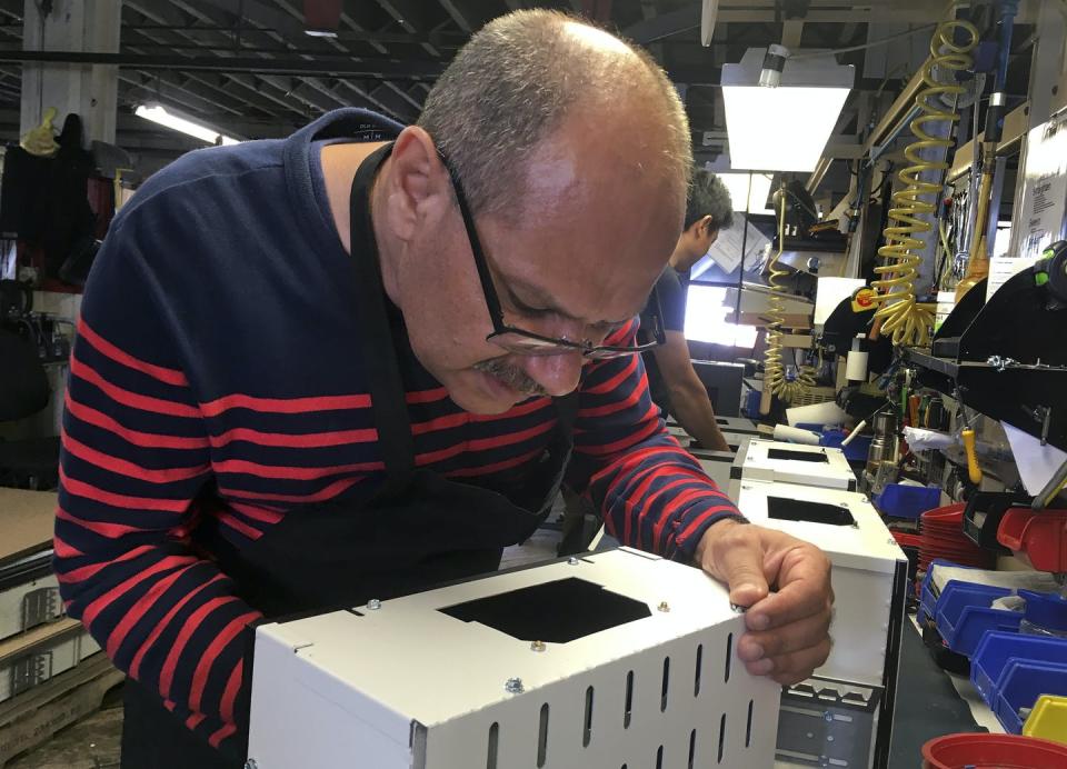 <span class="caption">Former Iraqi refugee Majid Al Lessa works on a lighting fixture on the assembly floor of LiteLab, a factory that employs refugees in Buffalo, N.Y.</span> <span class="attribution"><a class="link " href="http://www.apimages.com/metadata/Index/Trump-Fewer-Refugees/82f3346b282449d99e067ebe55913774/5/0" rel="nofollow noopener" target="_blank" data-ylk="slk:AP Photo/ Michael Hill;elm:context_link;itc:0;sec:content-canvas">AP Photo/ Michael Hill</a></span>