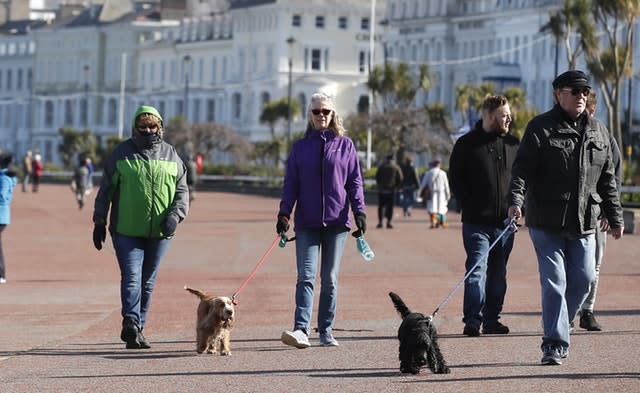 People walk along the promenade in Llandudno, north Wales, as the Government continues to advise the public to reduce social interaction