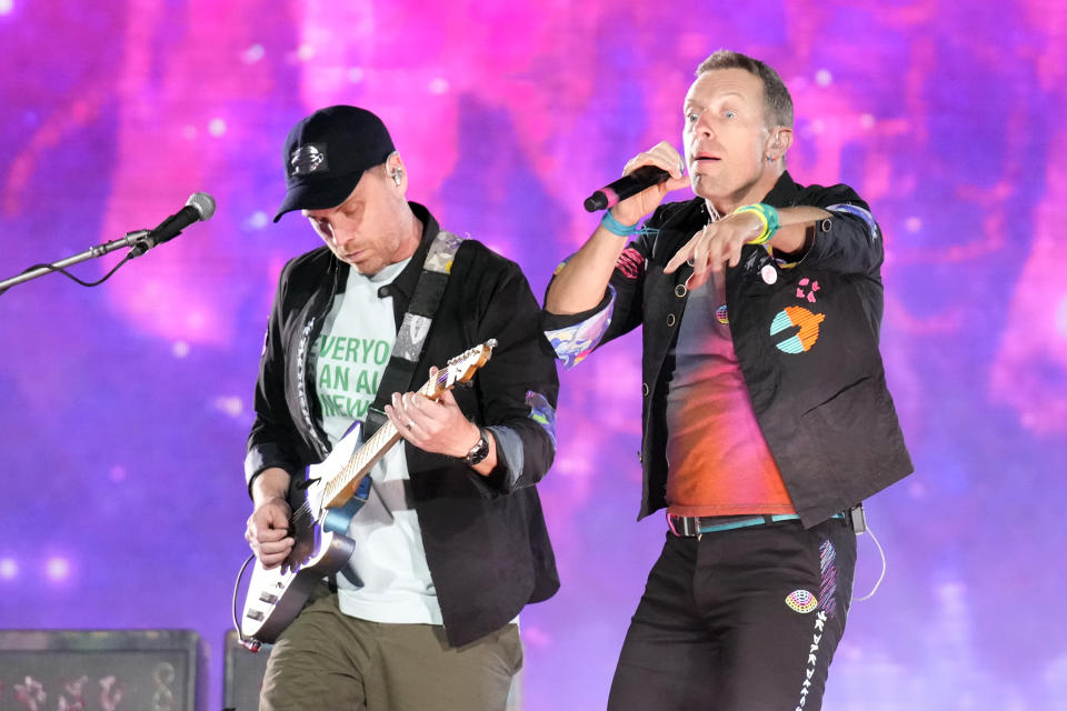 Jonny Buckland, left, and Chris Martin of Coldplay perform during the band's Music of the Spheres world tour on Thursday, May 12, 2022, at State Farm Stadium in Glendale, Ariz. (Photo by Rick Scuteri/Invision/AP)