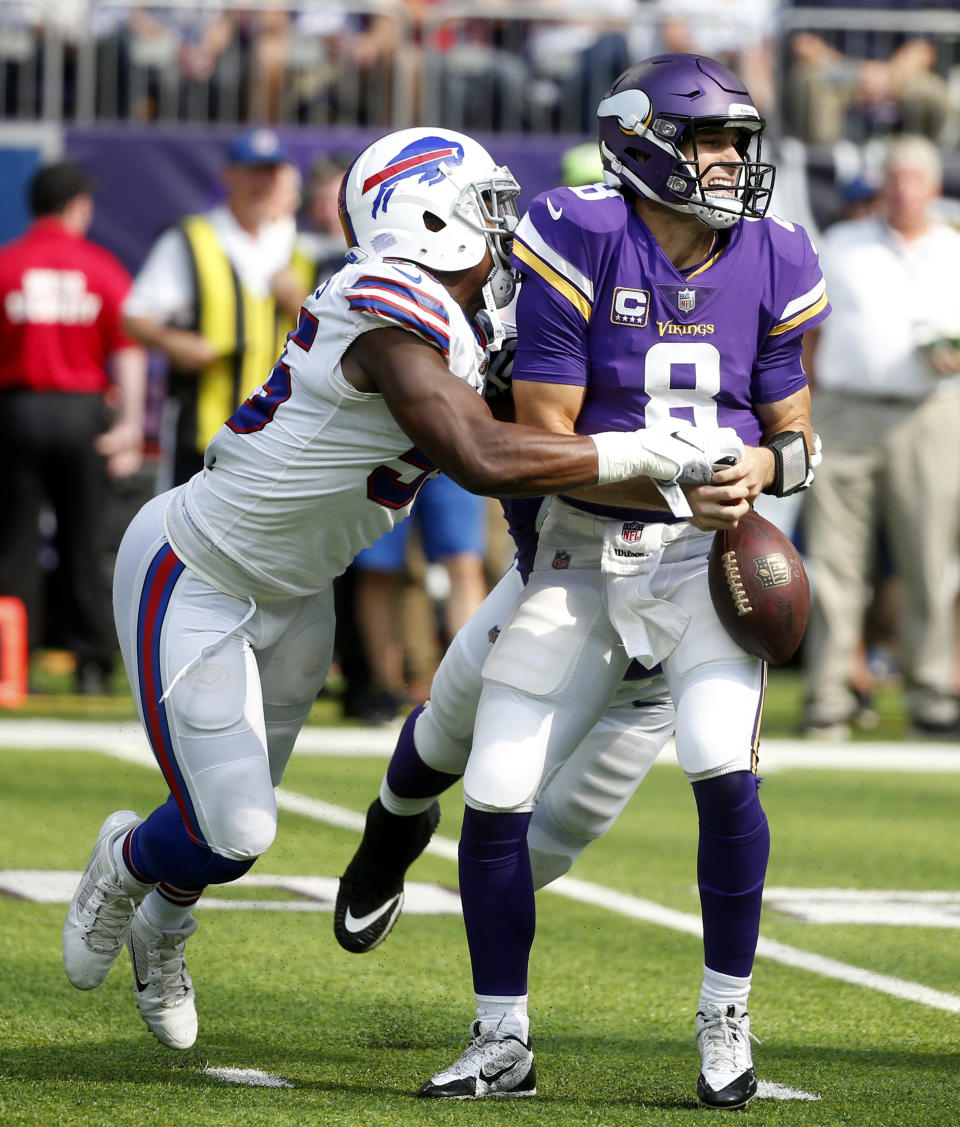 Minnesota Vikings quarterback Kirk Cousins (8) fumbles as he is hit by Buffalo Bills defensive end Jerry Hughes, left, during the first half of an NFL football game, Sunday, Sept. 23, 2018, in Minneapolis. (AP Photo/Bruce Kluckhohn)