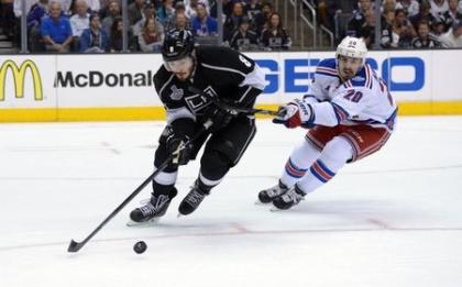 Doughty reaches for the puck against Rangers winger Chris Kreider during Game 1 of the 2014 Stanley Cup Final at Staples Ceneter in Los Angeles. (USA Today)