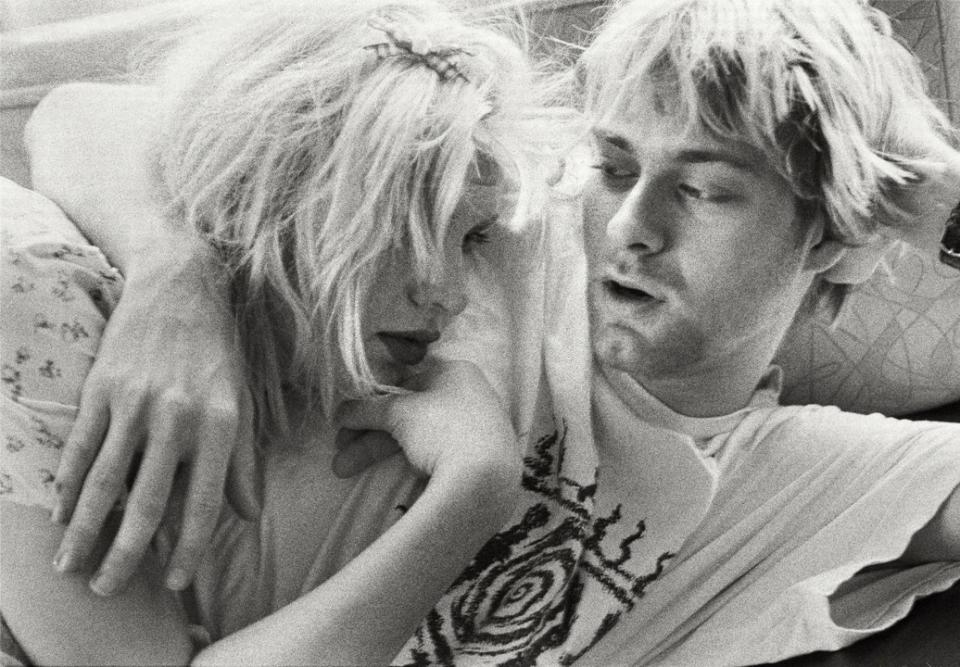 A black and white photo of Kurt Cobain and Courtney Love hugging